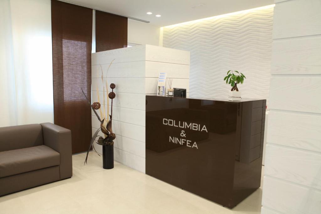 - un hall avec une chaise, une table et un mur dans l'établissement Hotel Columbia & Ninfea, à Lido di Jesolo