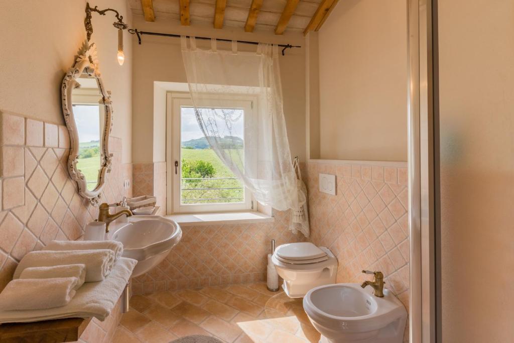 une salle de bain avec un lavabo et des toilettes et une fenêtre dans l'établissement Villa del Cucco, à Fossombrone 22 autres photos