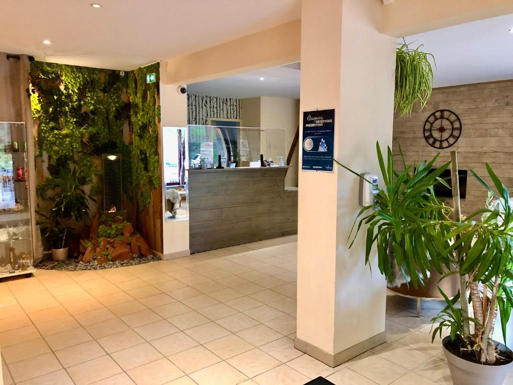 un hall d'un magasin avec des plantes dans l'établissement Adonis Valberg, à Valberg