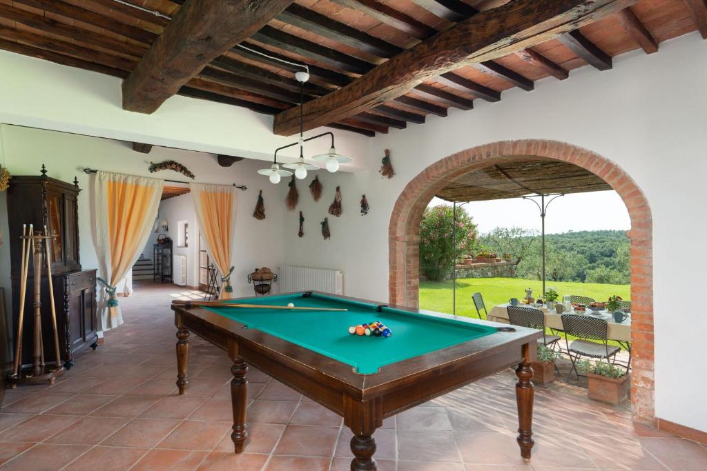 une table de billard dans un salon avec une salle d'arcade dans l'établissement Podere Le Pozze, à Sinalunga