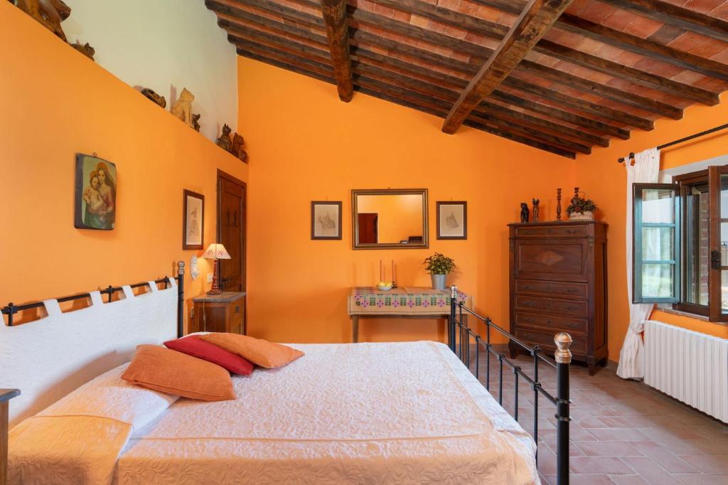 - une chambre avec un grand lit dans une pièce aux murs orange dans l'établissement Podere Le Pozze, à Sinalunga 34 autres photos