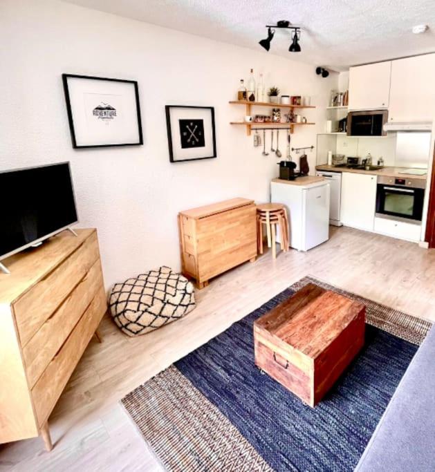 un salon avec une table et une cuisine dans l'établissement Studio Cocon aux Orres 1650 au pied des pistes et vue montagne, aux Orres