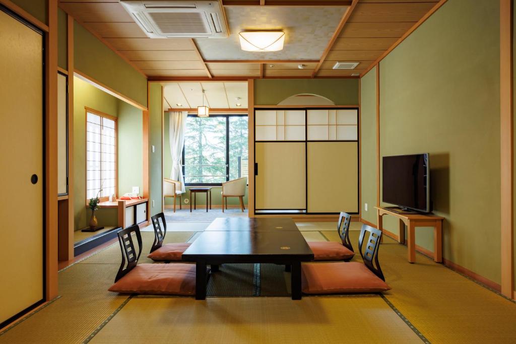 une salle de conférence avec une table, des chaises et une télévision dans l'établissement Matsusaki, à Nomi