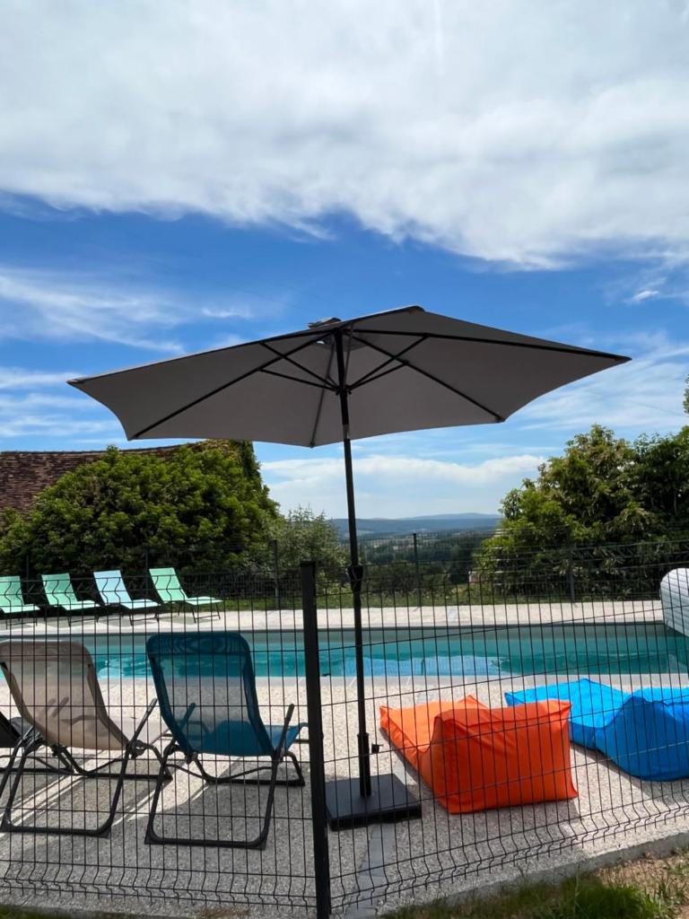 un parasol et des chaises à côté d'une piscine dans l'établissement Gîte de la Doit, en pleine campagne, pour 14 pers, à Saint-Marcelin-de-Cray