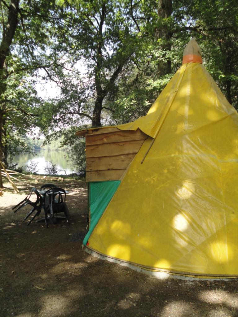 une tente jaune et verte à côté d'un arbre dans l'établissement air naturel de camping moulin de malesse Tipi, à Saint-Privat