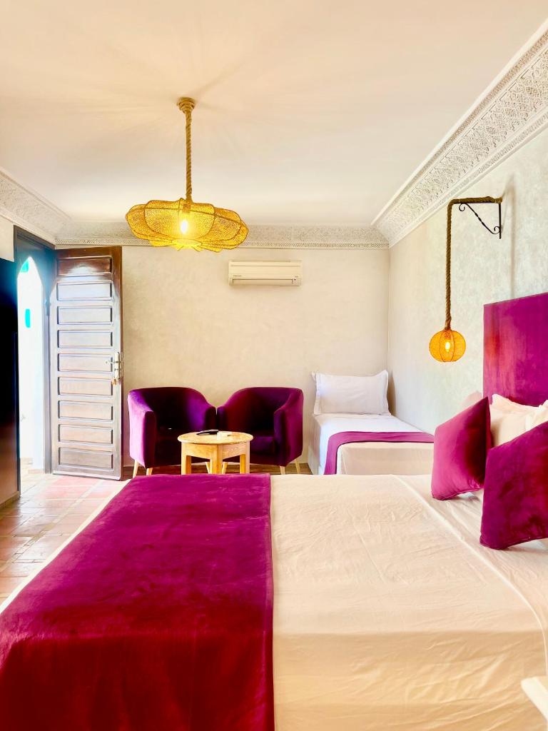 Cette chambre d'hôtel comprend 2 lits et des draps violets. dans l'établissement Riad Al Wafaa, à Marrakech