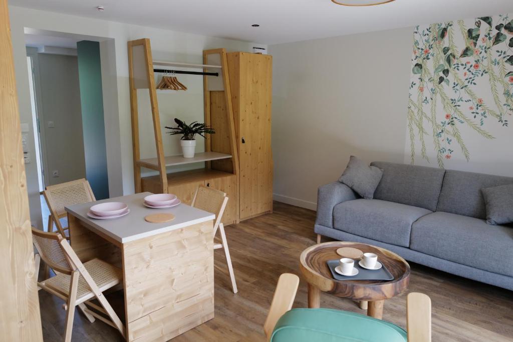 un salon avec un canapé, une table et des chaises dans l'établissement Les Gîtes d'Aillon et d'Ailleurs, à Aillon-le-Jeune