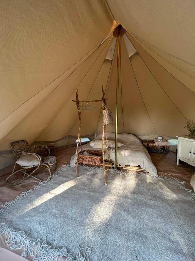 Cette chambre comprend une tente avec un lit. dans l'établissement Le Brasseur Logements - Tents, à Saint-Caprais