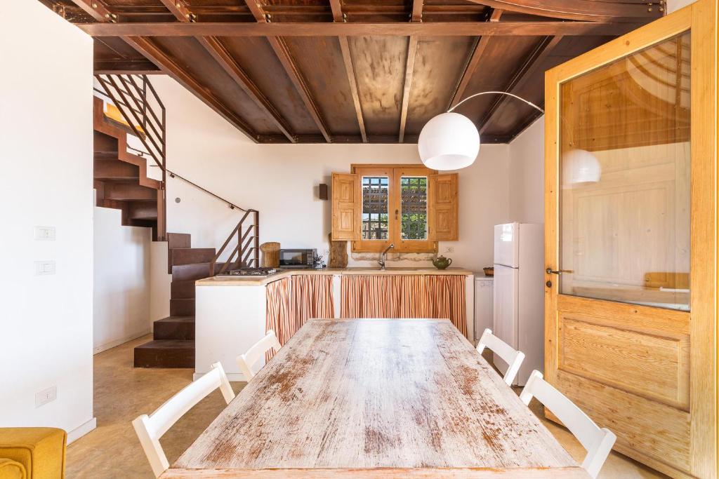 une cuisine et une salle à manger avec une table et des chaises en bois dans l'établissement Tenuta Terra del Sole by Perle di Puglia, à Ugento