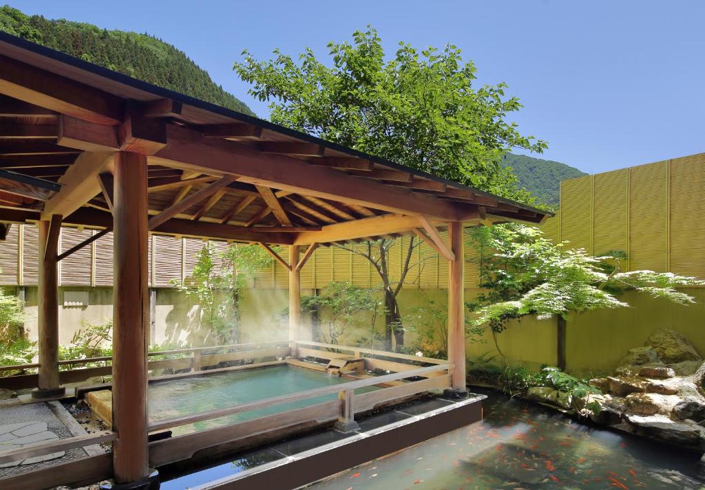 - une piscine sous un pavillon en bois à côté d'un étang dans l'établissement Tachibanaya, à Tsuruoka