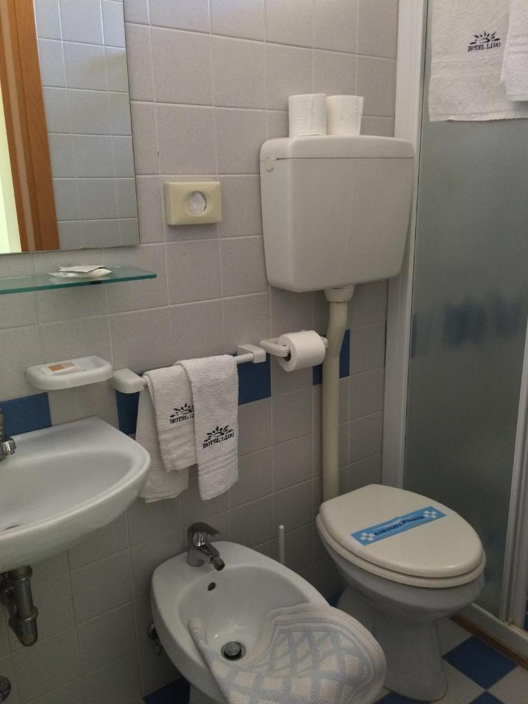 une petite salle de bain avec toilettes et lavabo dans l'établissement Hotel Lido, à Lido di Jesolo