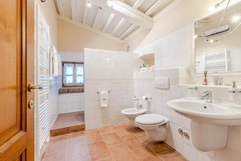 une salle de bain blanche avec un lavabo et des toilettes dans l'établissement Chateau La Siroque, à Montecatini Val di Cecina