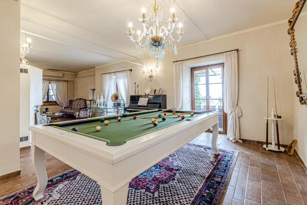 un salon avec un billard et un lustre dans l'établissement Chateau La Siroque, à Montecatini Val di Cecina