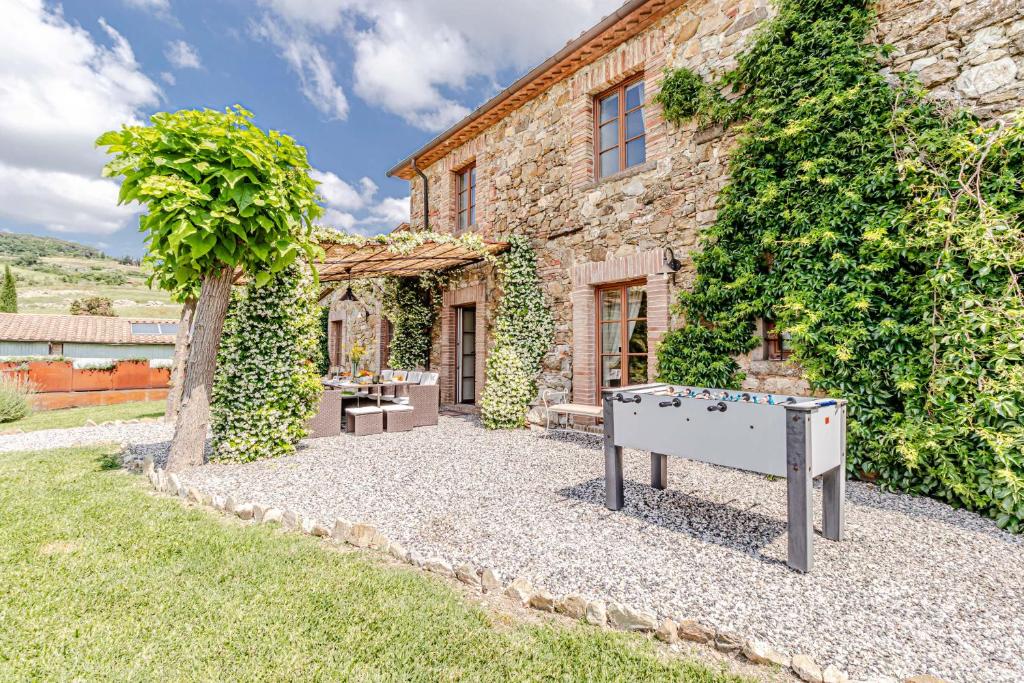 une maison en pierre avec une table de ping-pong devant dans l'établissement Chateau La Siroque, à Montecatini Val di Cecina