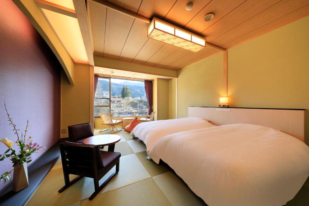 une chambre d'hôtel avec deux lits et une fenêtre dans l'établissement Wafu-no-Yado MASUYA, à Yamanouchi
