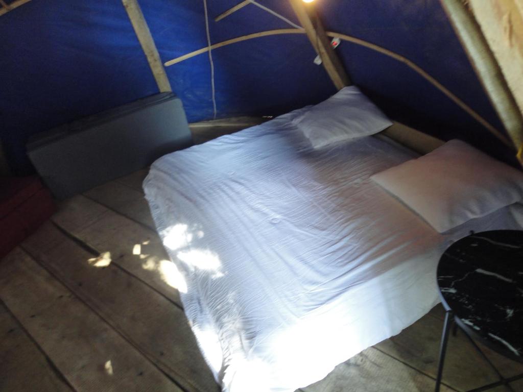 - une chambre bleue avec un lit blanc dans l'établissement air naturel de camping moulin de malesse Tipi, à Saint-Privat