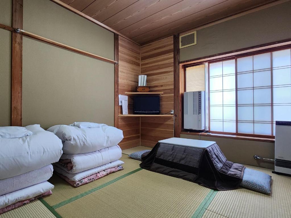 Cette chambre comprend un tas d'oreillers. dans l'établissement Minshuku Kojima, à Nozawa Onsen