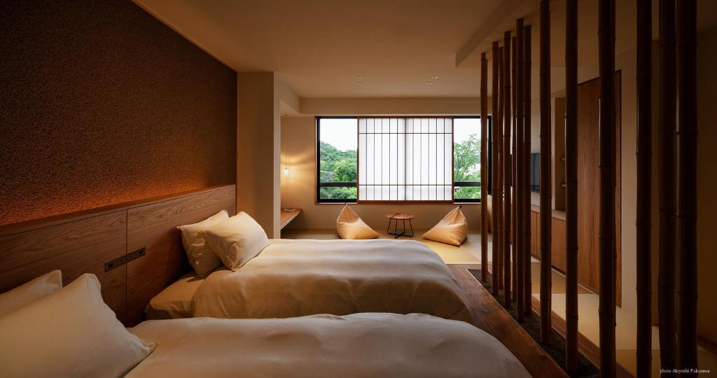 une chambre d'hôtel avec deux lits et une fenêtre dans l'établissement くろしお想, à Shirahama