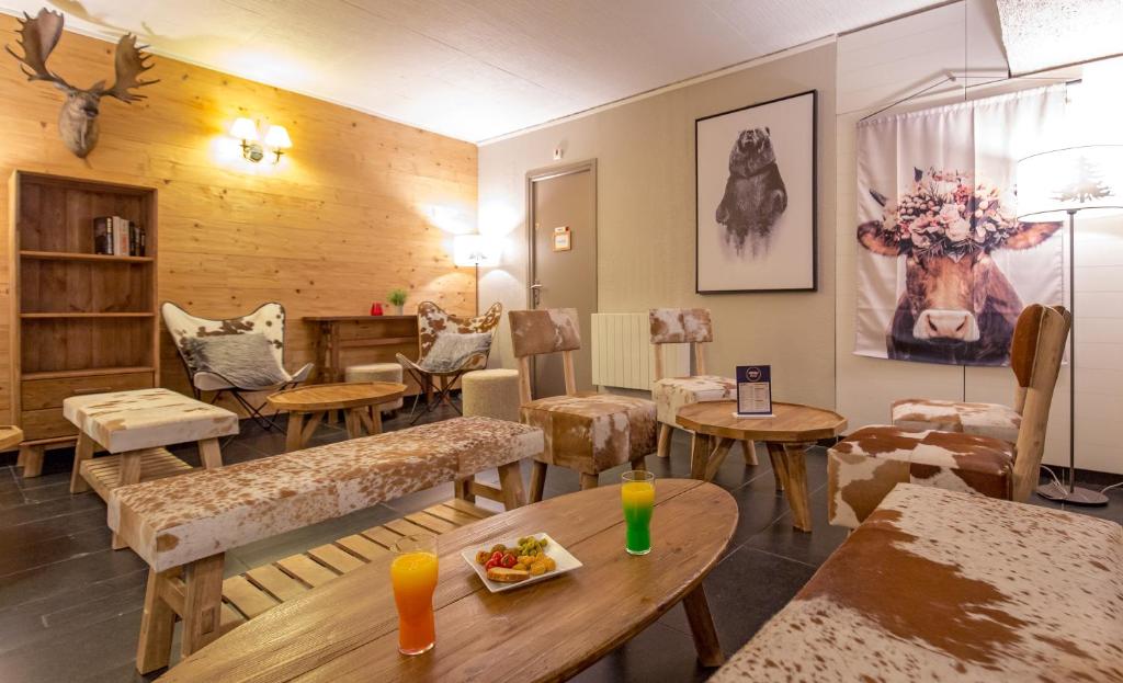un salon avec des tables et des chaises ainsi qu'une pièce dans l'établissement SOWELL HOTELS Le Pas du Loup, à Isola 2000