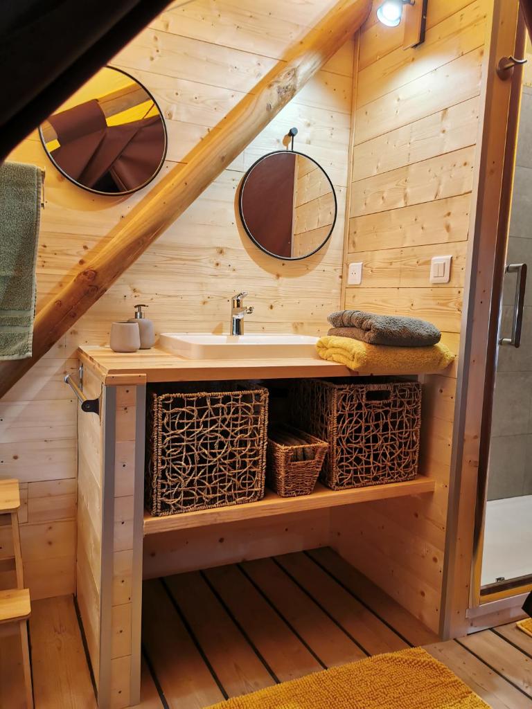 - une salle de bains avec lavabo dans une maison en bois dans l'établissement Le lodge cocooning, à Ansignan