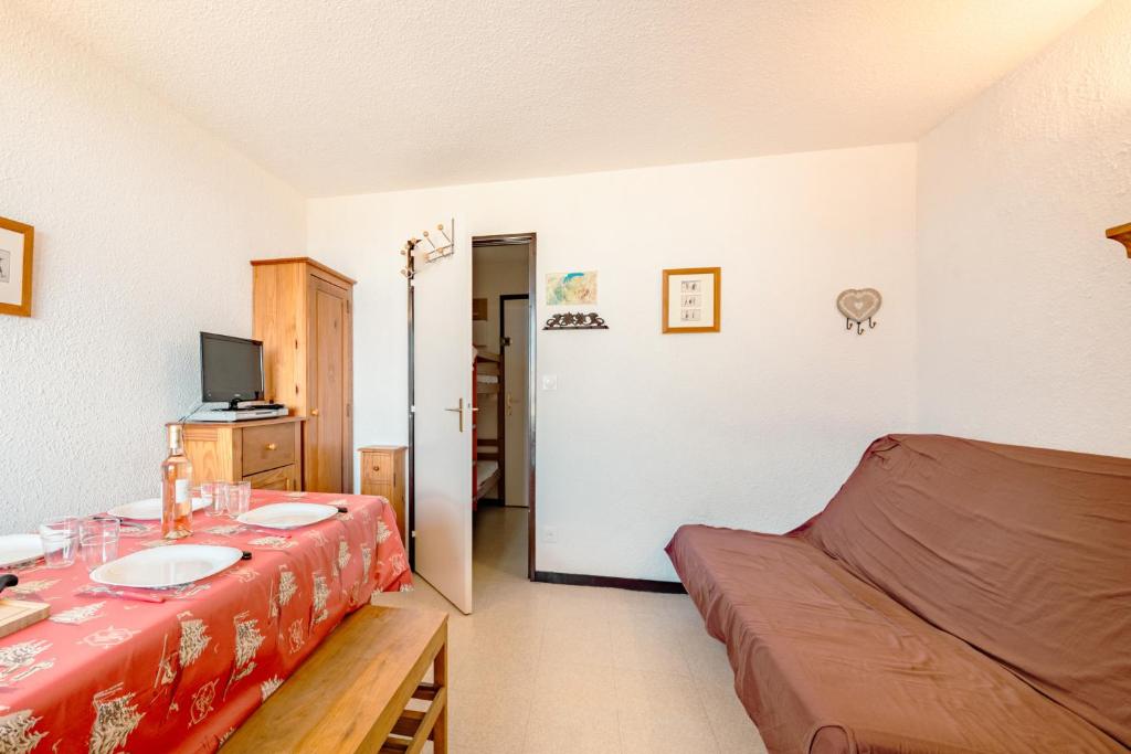 Cette chambre comprend un lit, une table et un canapé. dans l'établissement Appartement au pied des pistes, à Samoëns