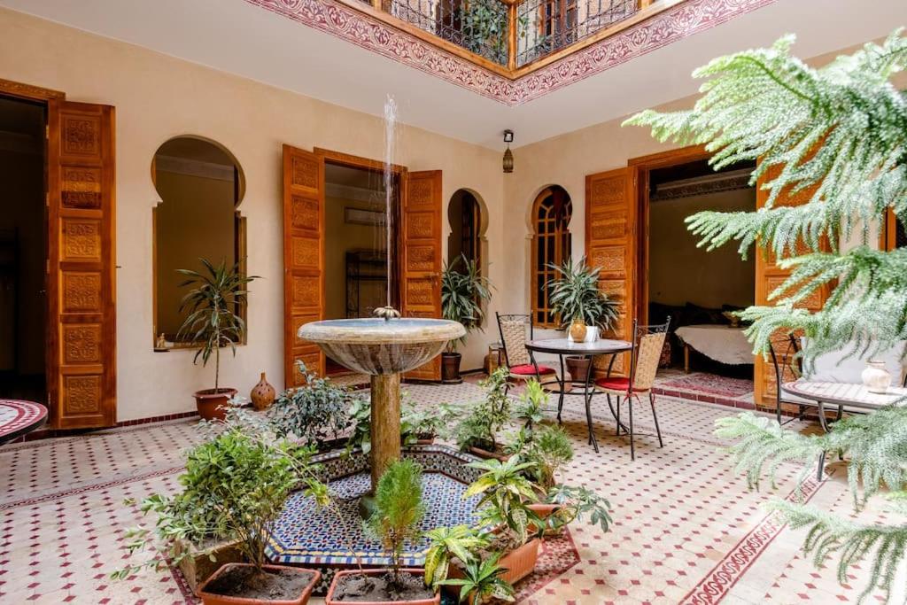une grande chambre avec une fontaine et des plantes dans l'établissement Riad Dar Saidi, à Rabat