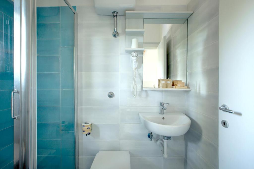 une salle de bain avec un lavabo, des toilettes et une douche dans l'établissement Torre San Vito Beach Hotel 3s, à Gaète