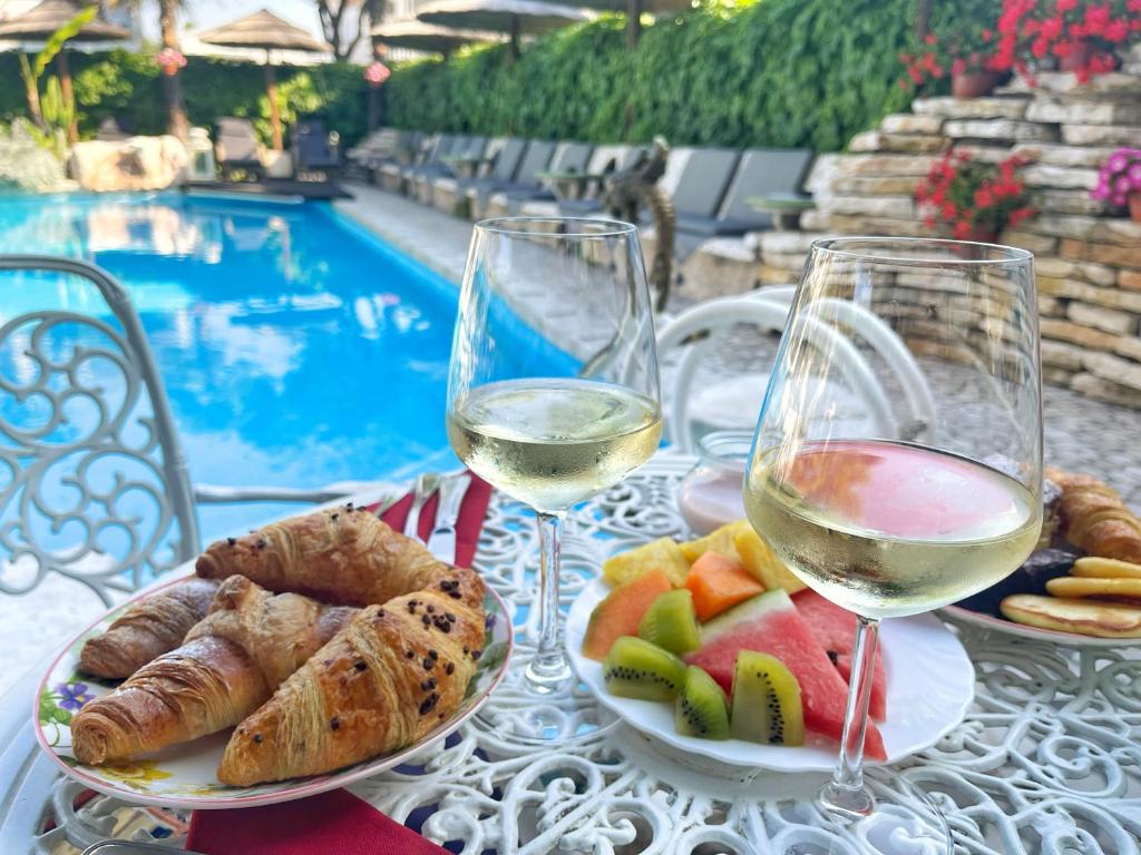 une table avec deux verres de vin, du pain et des fruits dans l'établissement Milton Boutique Hotel - Adults Only, à Lido di Jesolo