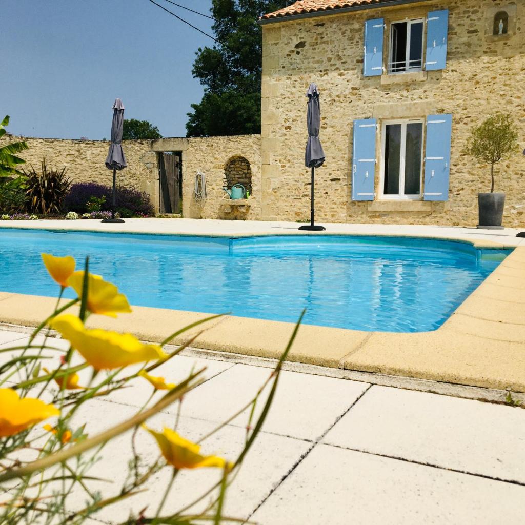 une piscine devant une maison dans l'établissement La Frouardière, 3 gîtes de charme, à Antigny