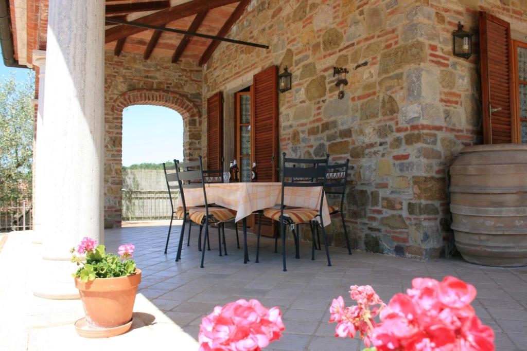 un patio avec une table et des chaises et un bâtiment dans l'établissement Villa Fosca, à Lucignano