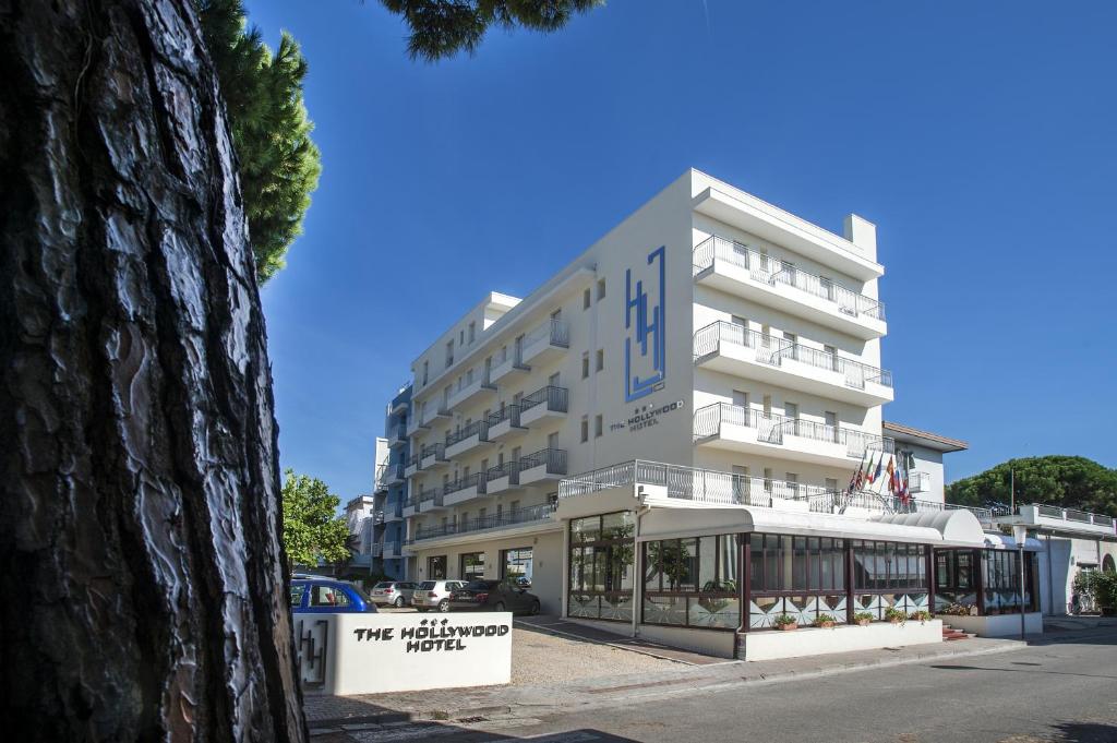 un bâtiment blanc avec un panneau devant dans l'établissement Hotel Hollywood***S, à Lido di Jesolo