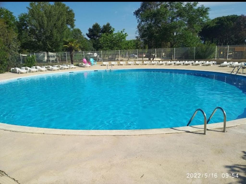 une grande piscine avec des chaises et de l'eau bleue dans l'établissement Vacances en Provence, à La Roque-dʼAnthéron
