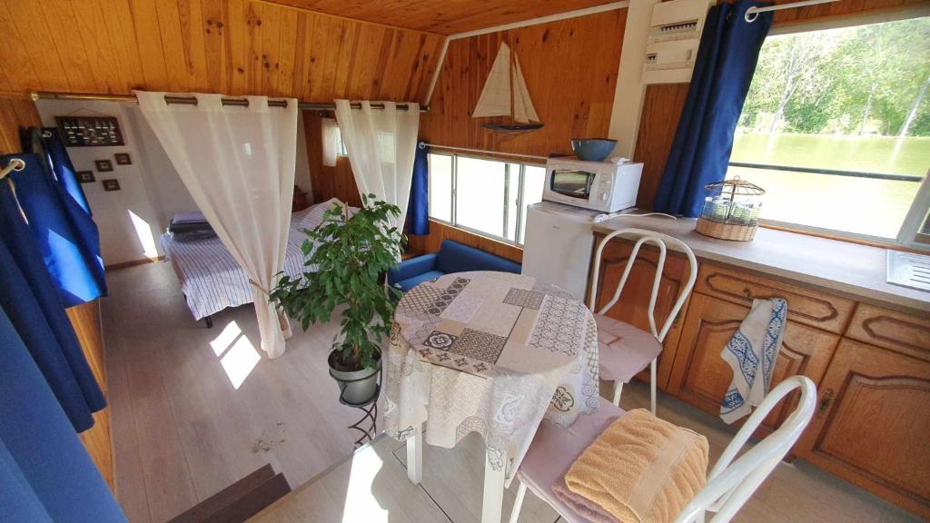 une salle à manger avec une table et une cuisine dans l'établissement Péniche la belle daisy, à Campsegret