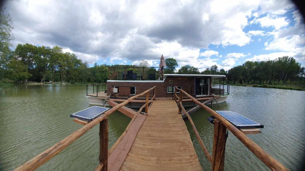 une petite maison sur un quai au bord d'un lac dans l'établissement Péniche la belle daisy, à Campsegret 5 autres photos