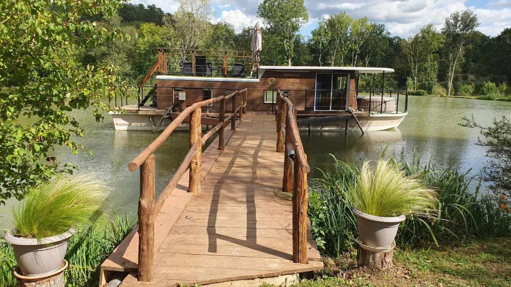 - un quai en bois avec un bateau sur l'eau dans l'établissement Péniche la belle daisy, à Campsegret