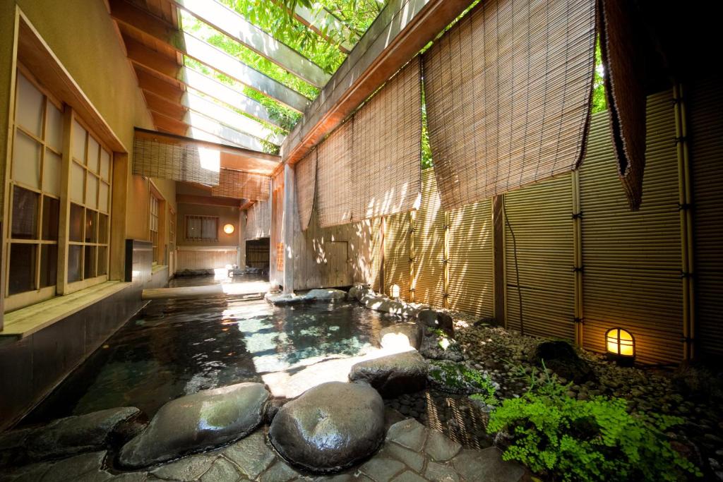 un bâtiment avec un étang en face d'un bâtiment dans l'établissement Ryotei Tanokura, à Yufu