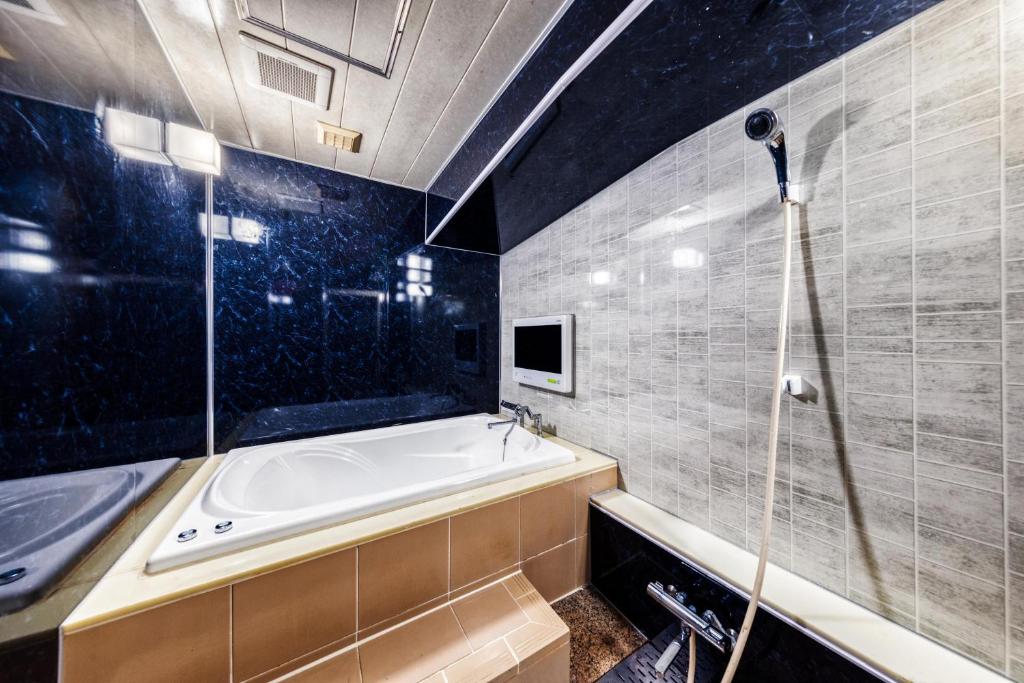 une salle de bain avec baignoire et douche dans l'établissement Hotel Luna Machida -Adult Only, à Machida