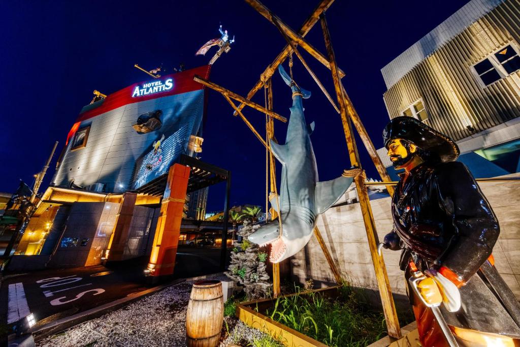 une statue d'un homme debout devant un bâtiment dans l'établissement Hotel Atlantis Machida -Adult Only, à Kami-seya