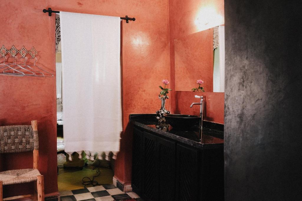 une salle de bain avec un lavabo noir et un miroir dans l'établissement Riad Maison 24, à Marrakech