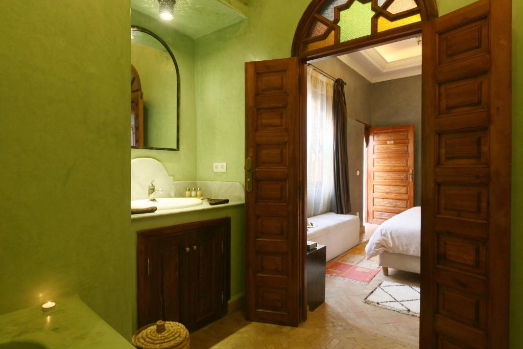 La salle de bains est pourvue d'un lavabo et d'un lit dans la chambre. dans l'établissement Riad L'Emir, à Marrakech