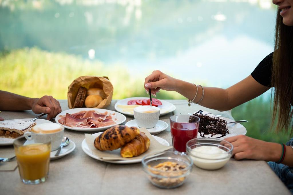un groupe de personnes assises à une table avec de la nourriture dans l'établissement Panoramic Hotel San Carlo Ledro, à Ledro 11 autres photos