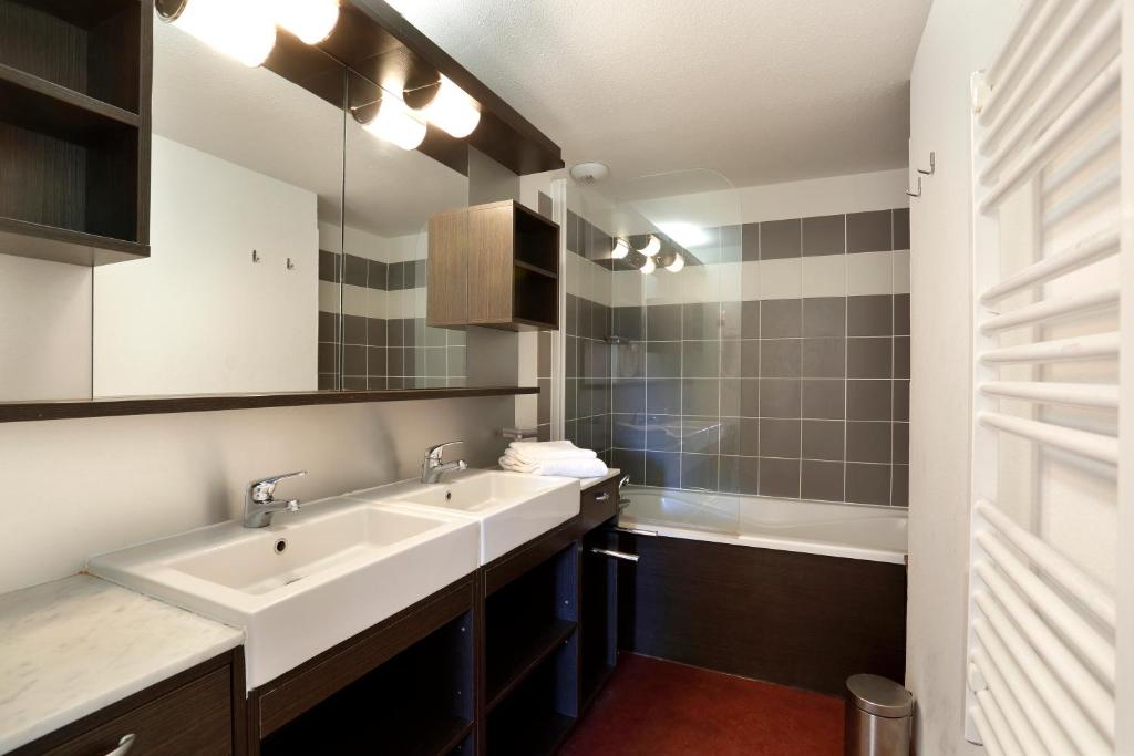 une salle de bain avec deux lavabos et un miroir dans l'établissement Vacancéole - Les Chalets du Verdon, à La Foux