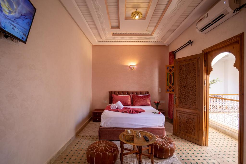 une chambre avec un lit et une table dans une pièce dans l'établissement Riad Petite Rose, à Marrakech 37 autres photos