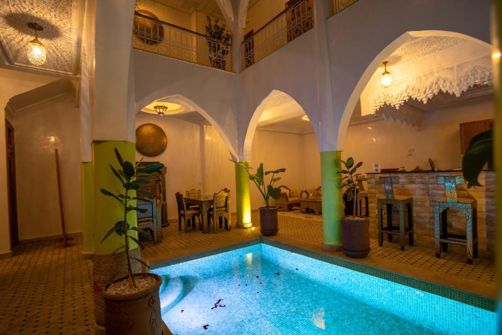 une grande chambre avec une piscine dans un bâtiment dans l'établissement Riad Petite Rose, à Marrakech