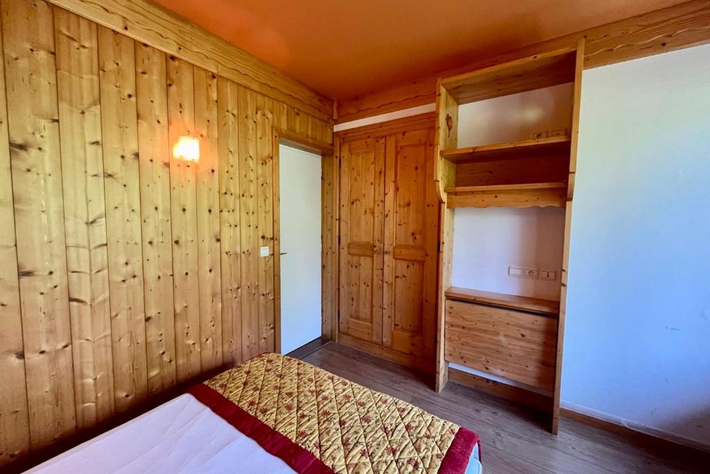 - une chambre avec des murs en bois et un lit dans un dortoir dans l'établissement Haven of peace with balcony in Combloux, à Combloux