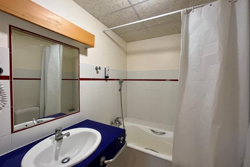 une salle de bain avec un lavabo, un miroir et une baignoire dans l'établissement Haven of peace with balcony in Combloux, à Combloux
