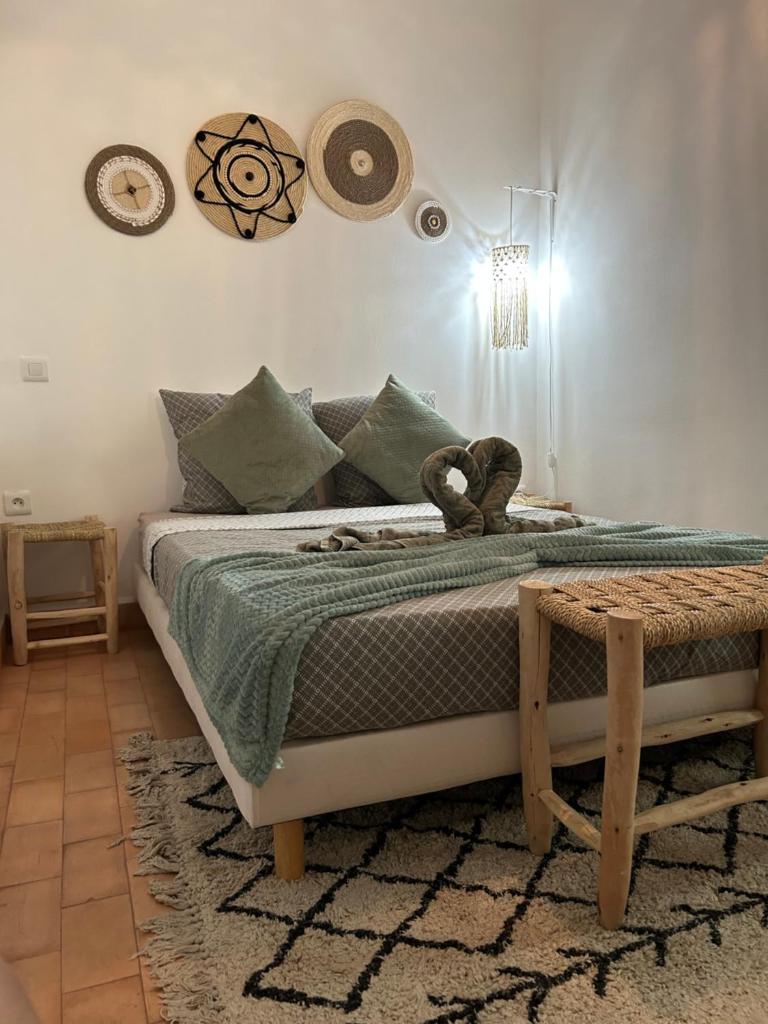 une chambre avec un lit avec un ours en peluche dessus dans l'établissement RIAD TIFAWT, à Marrakech