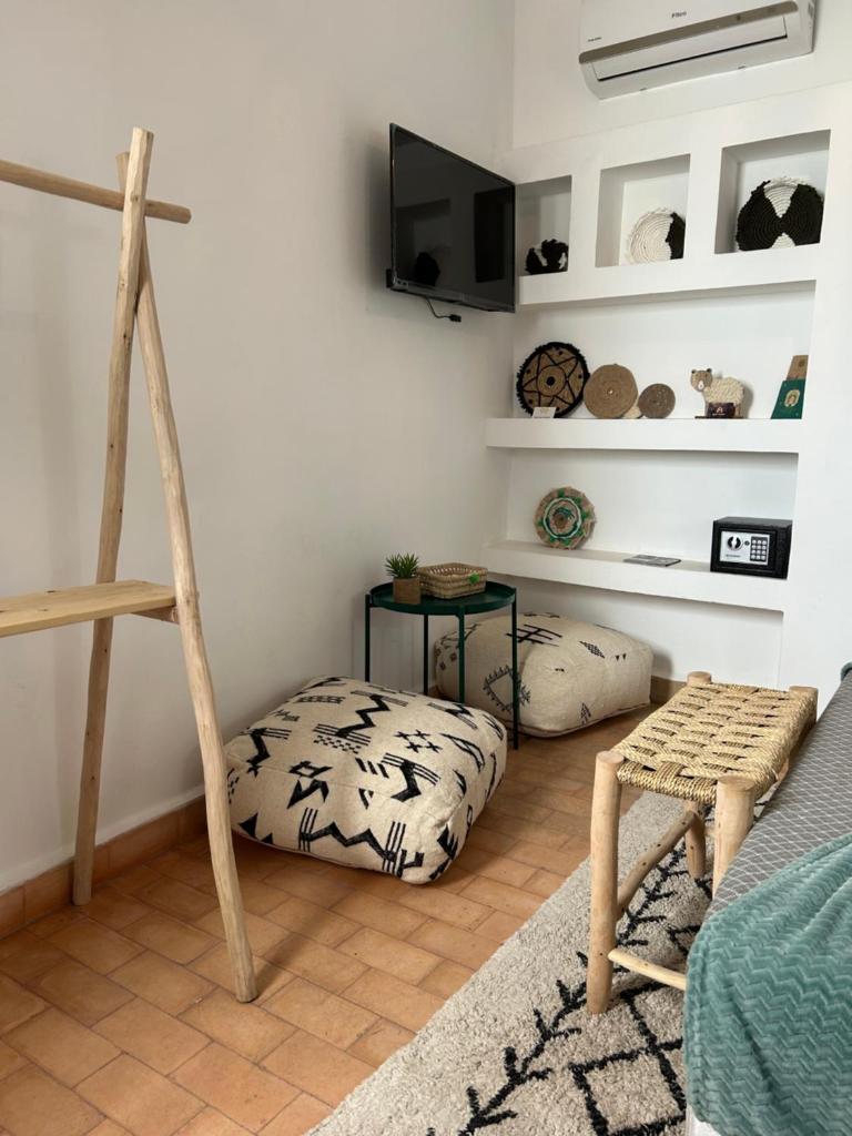 - un salon avec un lit pour chien et une télévision dans l'établissement RIAD TIFAWT, à Marrakech