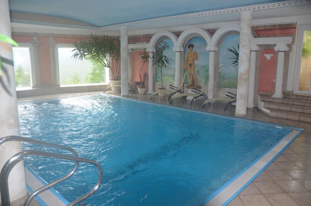 une grande piscine avec des chaises dans un bâtiment dans l'établissement Alpenlandhotel Rodeneggerhof, à Rodengo