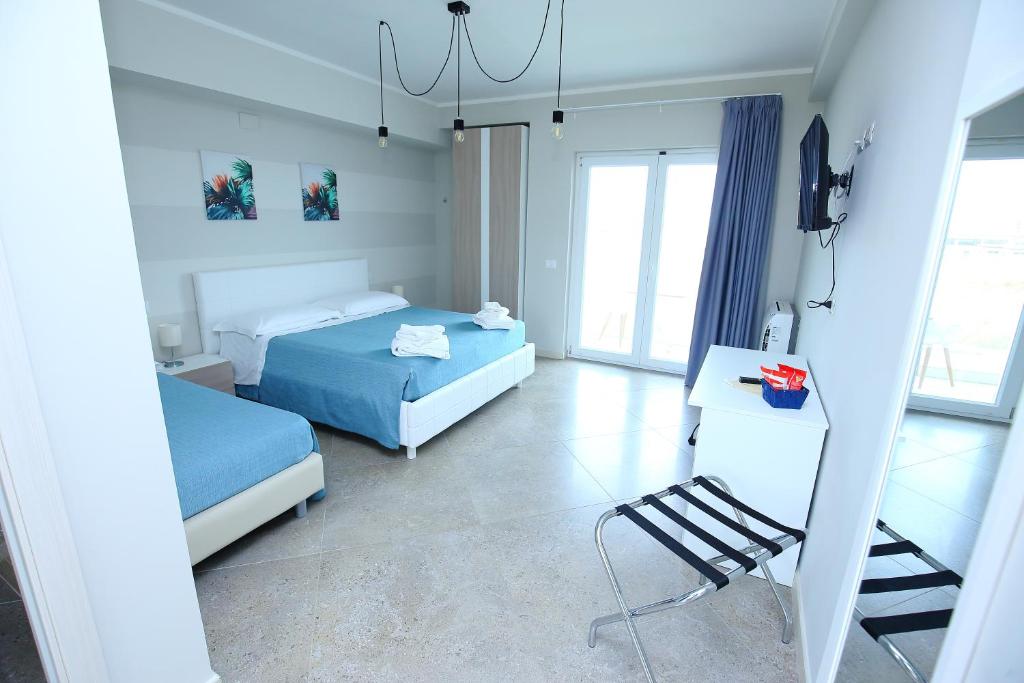 - une chambre avec 2 lits et une chaise dans l'établissement Sand Hotel, à Botricello